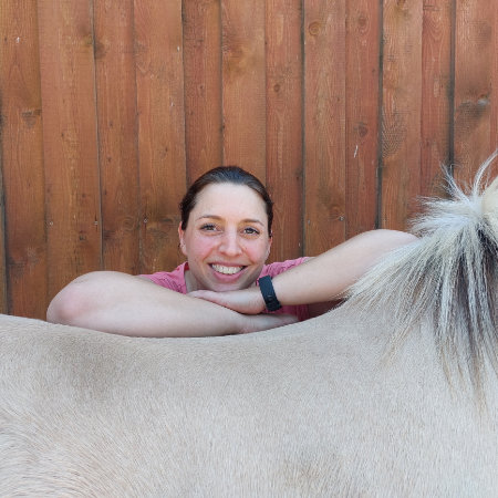 Sandra Hoffmann schaut über den Rücken ihres Fjordpferds Mogli
